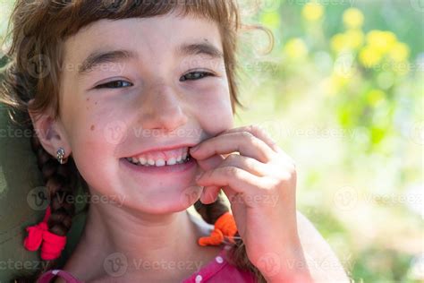 Summer Portrait Of A Happy Baby Girl With A Perky And Mischievous Smile