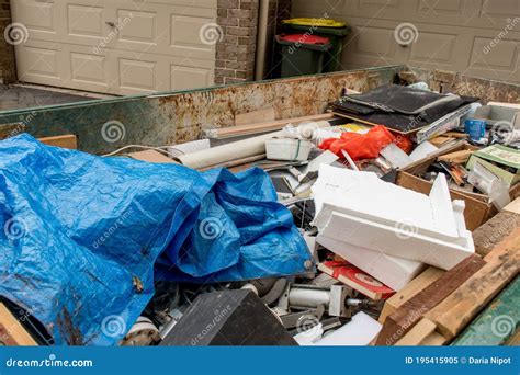 Rubbish Skip Full Of Cardboard Pipe And Housing Material On Busy City