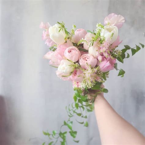 A Hand Holding A Bouquet Of Pink And White Flowers