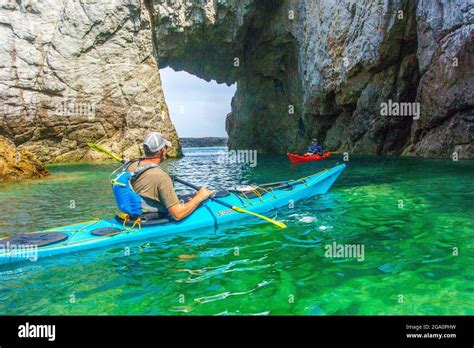 Exploring Sea Caves Whilst Sea Kayaking Off The Coast Of Anglesey