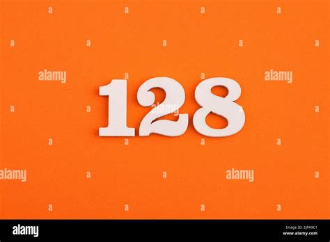 White wooden number 128 on eva rubber orange background Stock Photo - Alamy