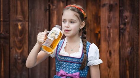 Premium Photo Beautiful Young Brunette Girl In Dirndl Drinks Out Of