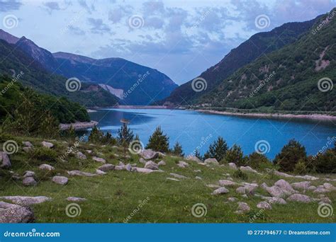 Tranquil Lake Nestled Among Lush Green Hills And Majestic Mountains