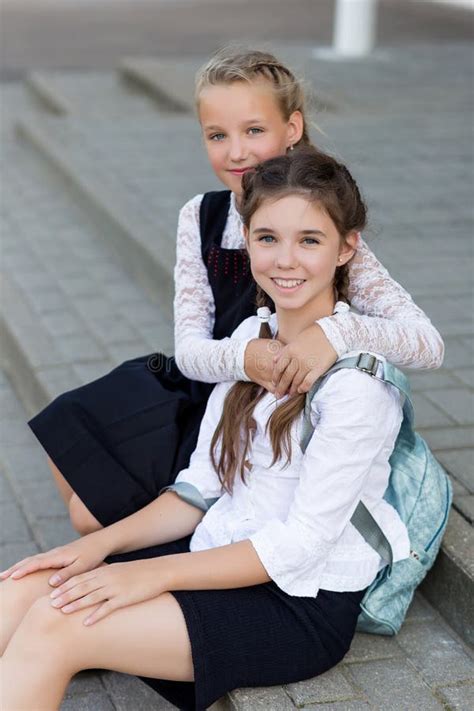 Les écolières Dans Des Uniformes Scolaires Sasseyent Pour Des Couples