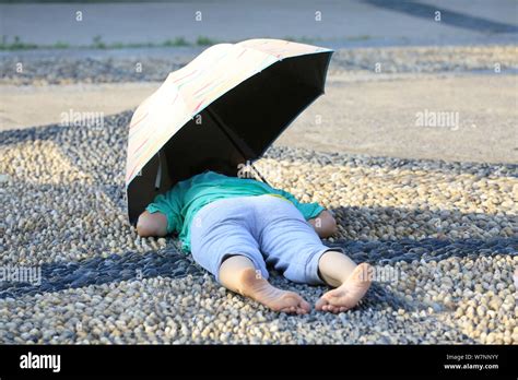 A Chinese aunt lies on the ground paved with cobblestones for hot stone ...