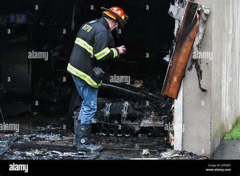 A Firefighter Investigates The Scene Fire Destroys Vehicle Inside Of A