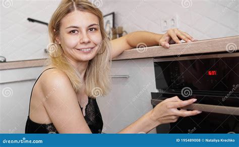 Mujer Cocinando En La Cocina Abriendo La Puerta Del Horno Foto De Archivo Imagen De Lifestyle