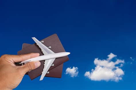 Premium Photo Cropped Hand Holding Passport And Toy Airplane Against