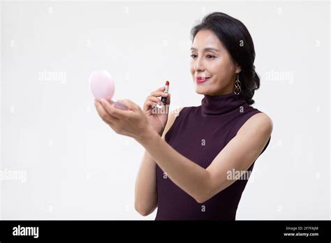 Mature Woman Applying Lipstick Stock Photo Alamy