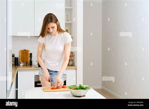 Young Attractive Woman Preparing Healthy Vegetable Salad In Modern