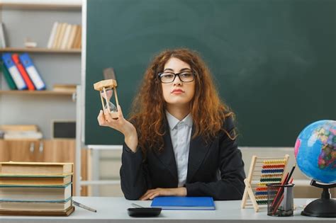 Una Joven Maestra Disgustada Con Gafas Sosteniendo Un Reloj De Arena