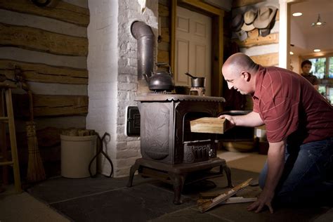 Stove Free Stock Photo A Man Placing Wood Into A Stove 16951