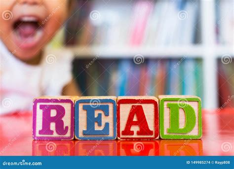 Alphabet Blocks Spelling The Word Read In Front Of A Bookshelf And An