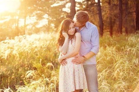 Jeunes Couples Dans Lamour Au Coucher Du Soleil Au Champ Image Stock