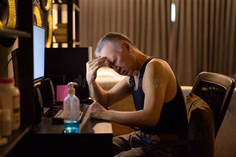 Stressed Mature Japanese Man Having Headache While Working From Home