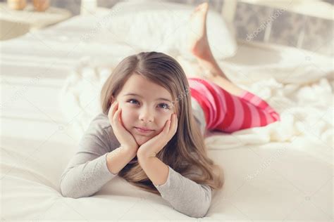 Portrait d une jolie petite fille se réveillant et couchée au lit le