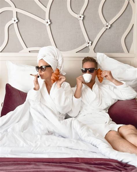 Two People Sitting On A Bed With Towels Wrapped Around Their Heads One