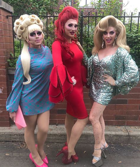 Three Women Dressed In Costumes Standing Next To Each Other Near A