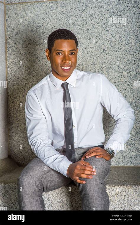 Dressing In White Shirt A Black Tie Gray Pants Hands Resting On His