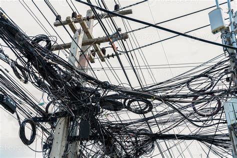 cables eléctricos enredados en poste eléctrico urbano desorganizado y