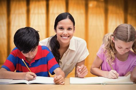 Bonita Profesora Ayudando A Los Alumnos En La Biblioteca Contra La