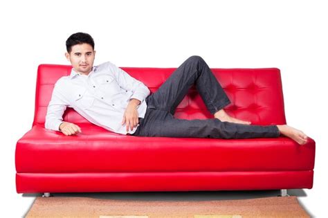 Premium Photo Portrait Of Young Man Sitting On Sofa Against White