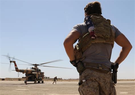 Us Navy Seal Watches As Iraqi Troops Exit A Helicopter During Advise