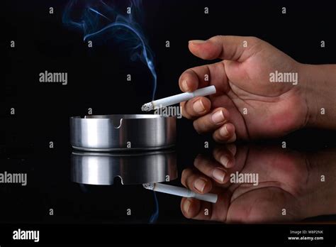 Hand Holding Cigarette On Black Background Stock Photo Alamy