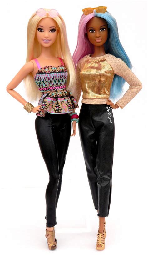 Two Barbie Dolls Standing Next To Each Other