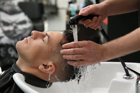 Professional Barber Washing Client`s Hair At Sink In Salon Closeup