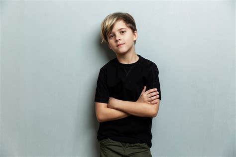 Um menino de 9 anos uma camiseta preta em pé os braços cruzados