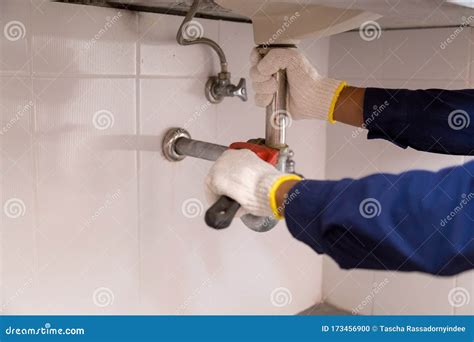 Plumber Fixing White Sink Pipe With Adjustable Wrench Stock Photo