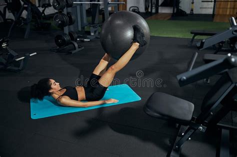 Concentrated Brunette Woman Keeping Ball Between Feet Stock Image