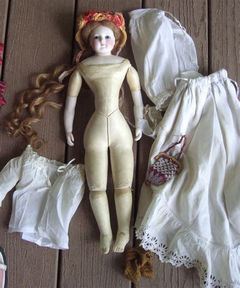 A Doll Laying On Top Of A Wooden Floor Next To Clothes