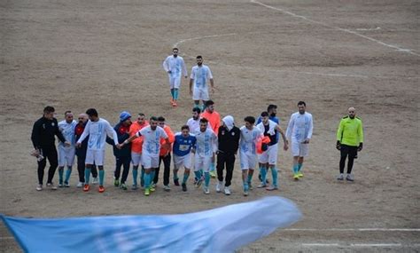 A Group Of Men Standing Next To Each Other On A Field