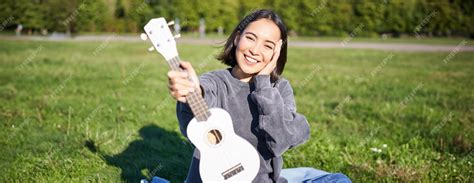 Premium Photo Beautiful Asian Girl With Happy Smile Shows Her Ukulele