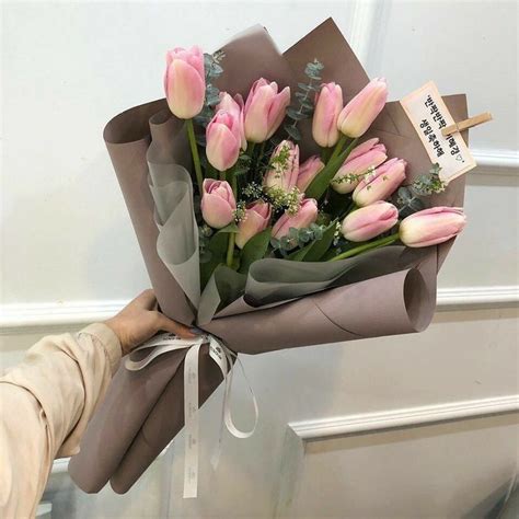 A Bouquet Of Pink Tulips Wrapped In Brown Paper