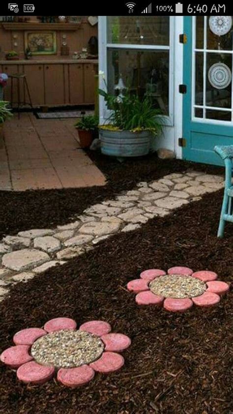 Two Flower Stepping Stones On The Ground In Front Of A Blue Door And