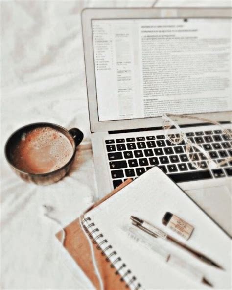 An Open Laptop Computer Sitting On Top Of A Bed Next To A Cup Of Coffee