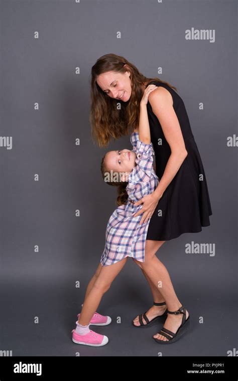 Mother And Daughter Bonding Together Against Gray Background Stock