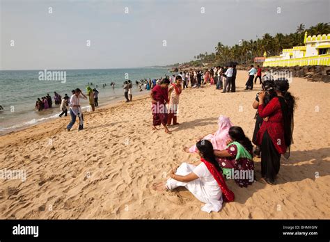 India, Kerala, Kovalam, Samudra Beach, Indian tourists sat on beach ...