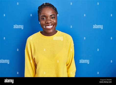 Beautiful Black Woman Standing Over Blue Background With A Happy And Cool Smile On Face Lucky