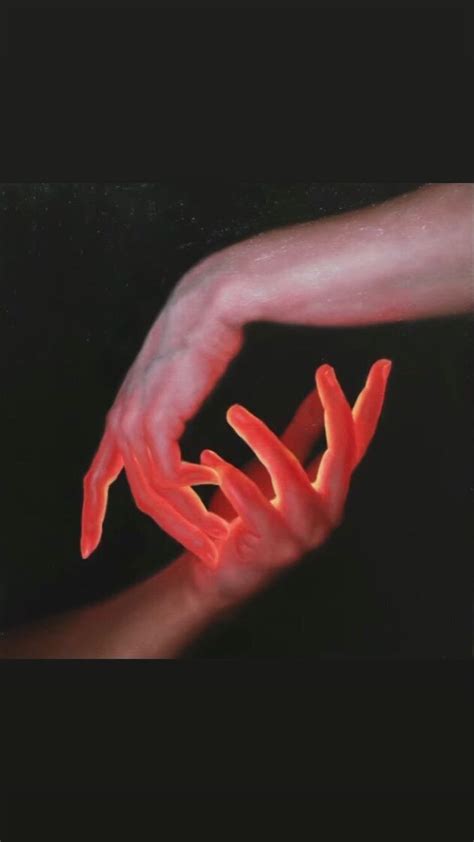 Two Hands Reaching Towards Each Other With Red Light Coming From Their