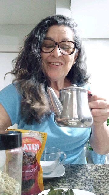 A Woman Is Holding A Tea Pot And Smiling