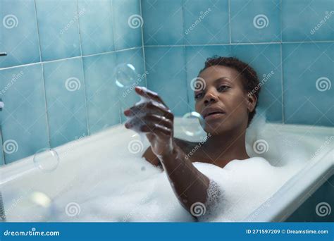 African American Woman Taking A Bath With The Bathtub Full Of Foam And