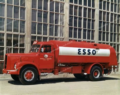 An Old Red Tanker Truck Parked In Front Of A Building