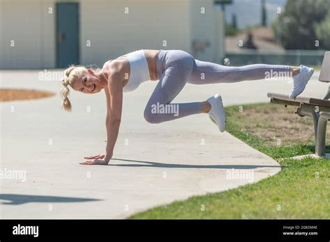 Healthy And Fit Atrractive Blonde Woman Bridging On Park Sidewalk To