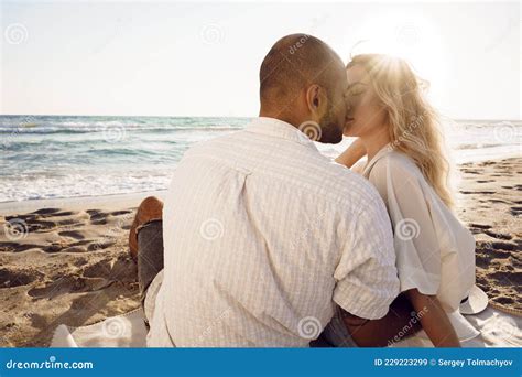 Beautiful Couple Sitting At The Beach Watching The Sunset Stock Image