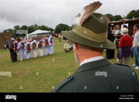 A Man Wearing A Traditional Austrian Hat Watches A Dance By Emirate Men