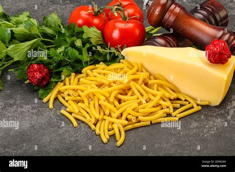 Italian pasta raw Maccheroni for cooking served vegetables Stock Photo ...